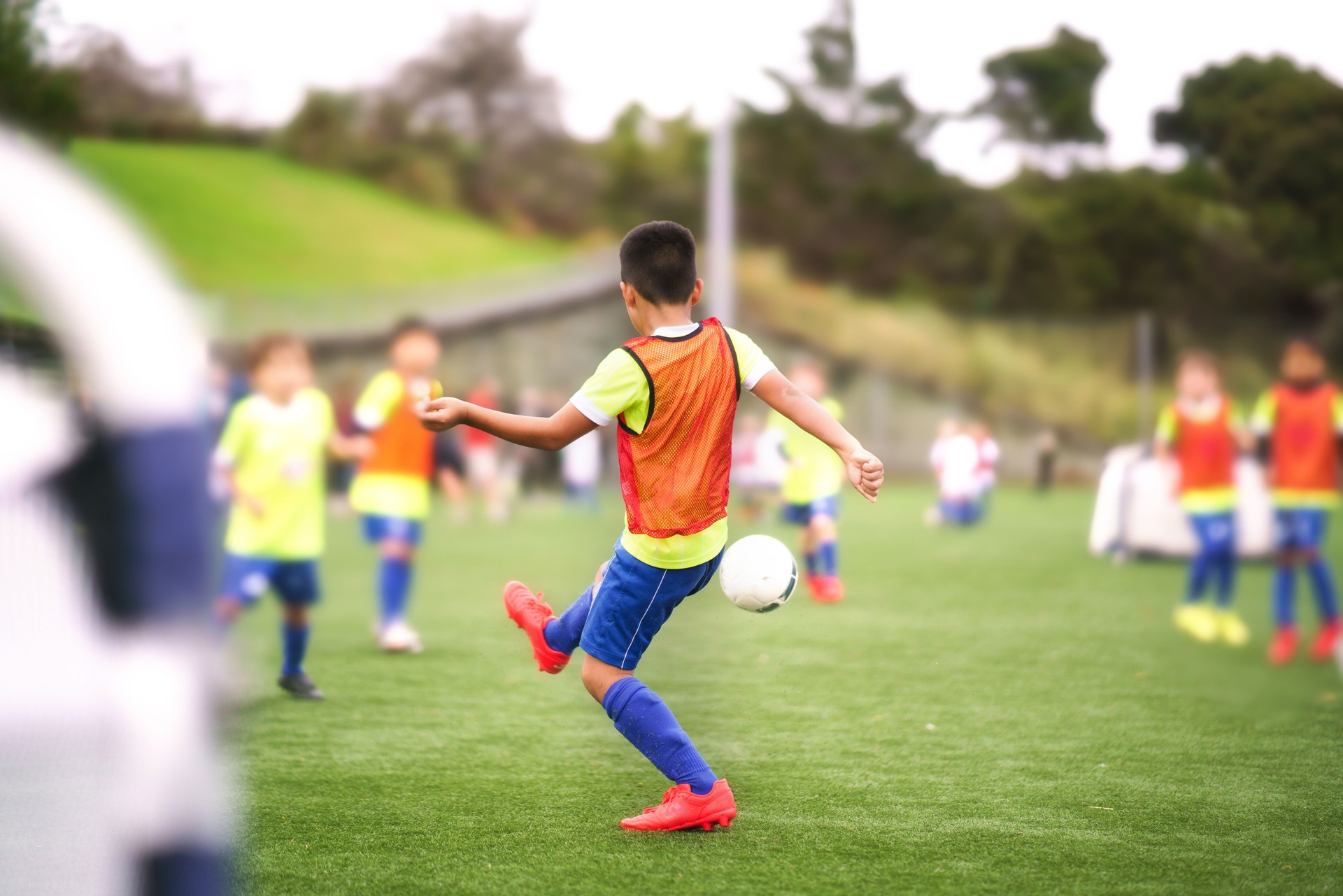 Kid playing soccer with his team.